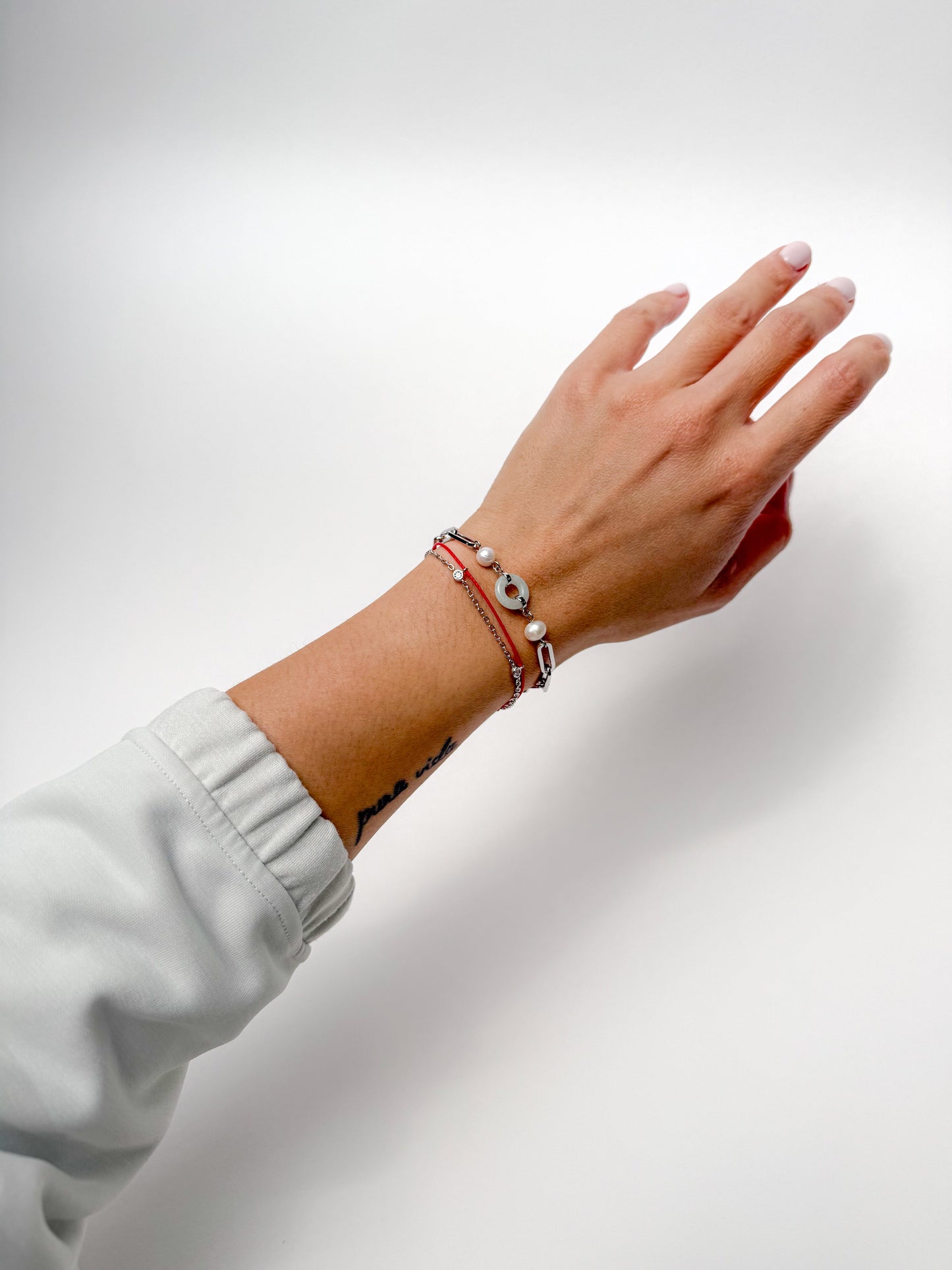 Dragon zodiac red string bracelet with white gold chain, flat lay - Crowned