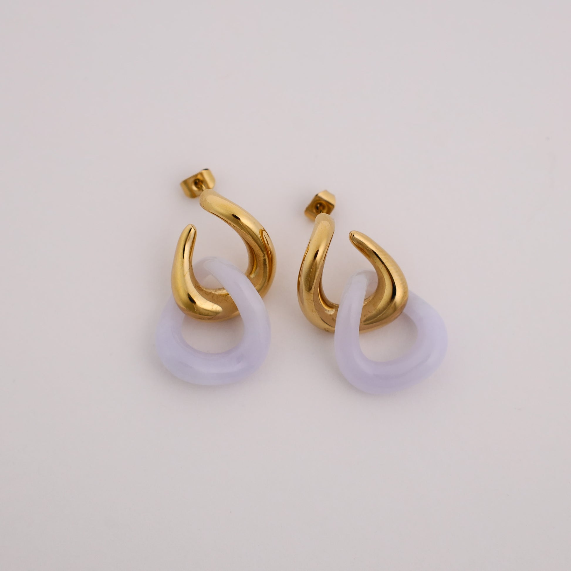 Twist of Fate Earrings, gold twisted drop earrings, flat lay - Crowned