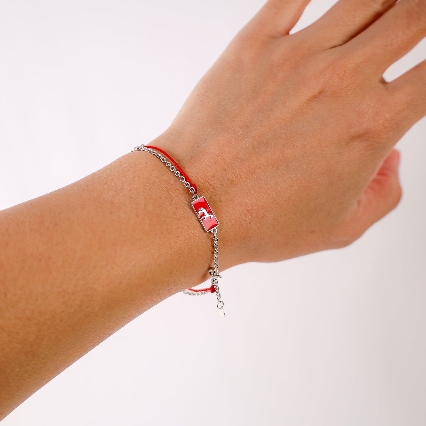 Horse zodiac red string bracelet with white gold chain, flat lay - Crowned
