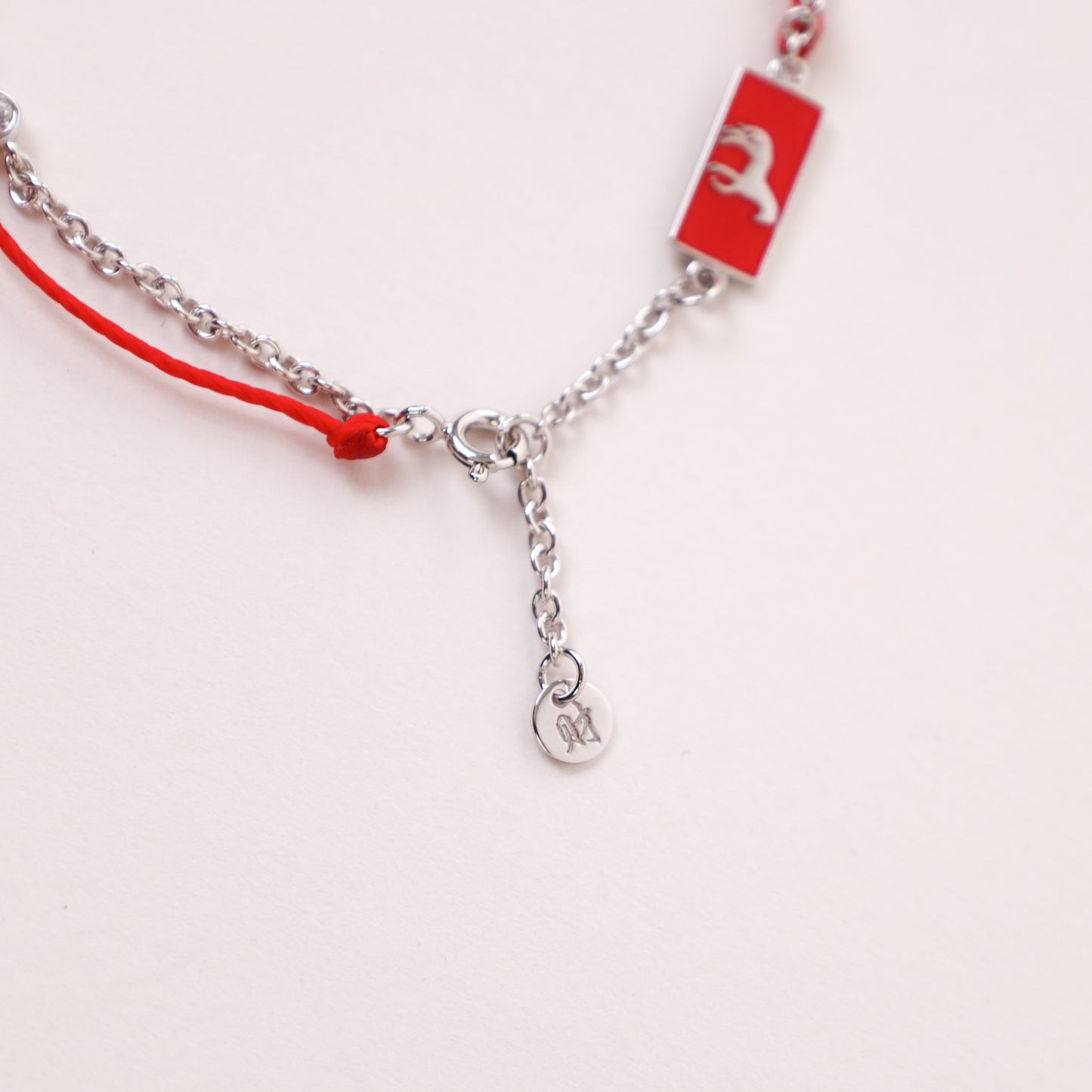 Horse zodiac red string bracelet with white gold chain, flat lay - Crowned