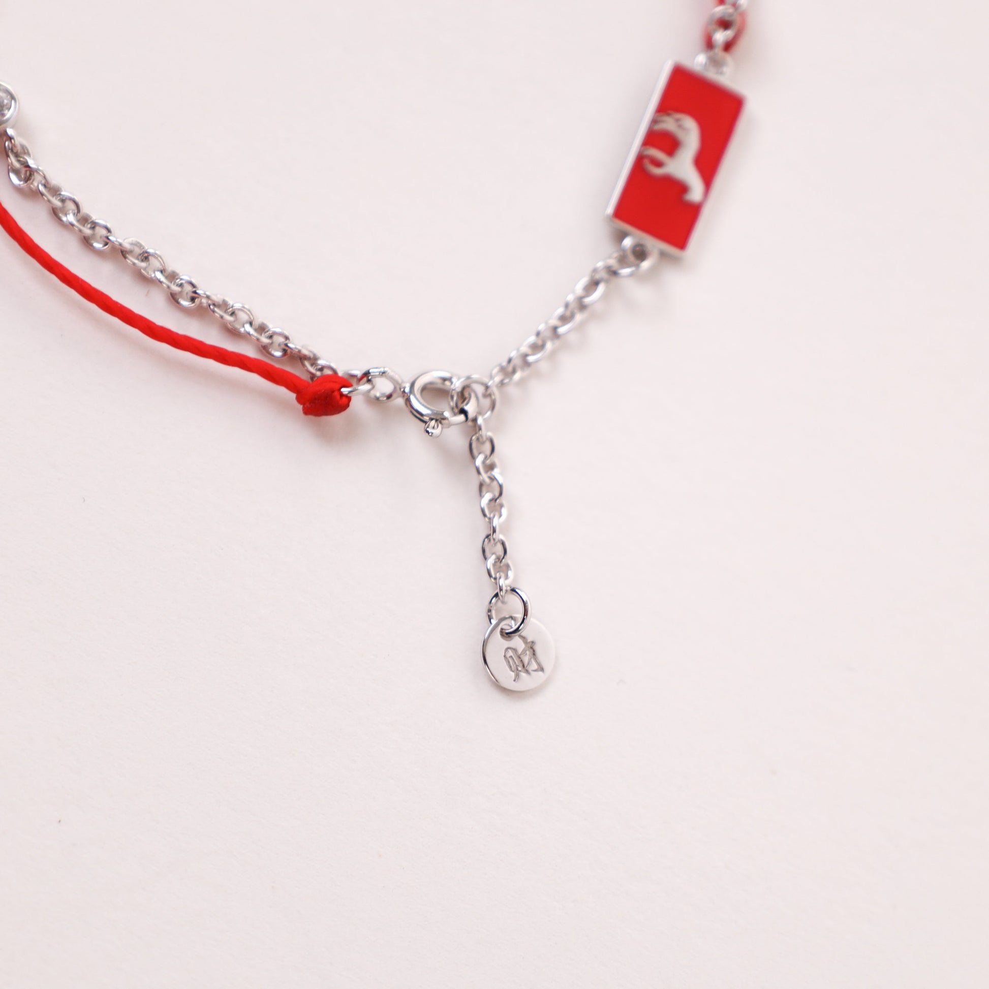 Horse zodiac red string bracelet with white gold chain, flat lay - Crowned