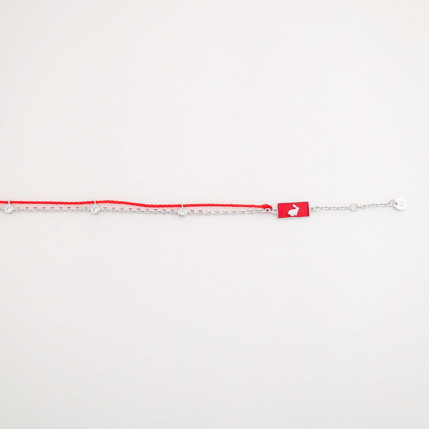 Rabbit zodiac red string bracelet with white gold chain, flat lay - Crowned