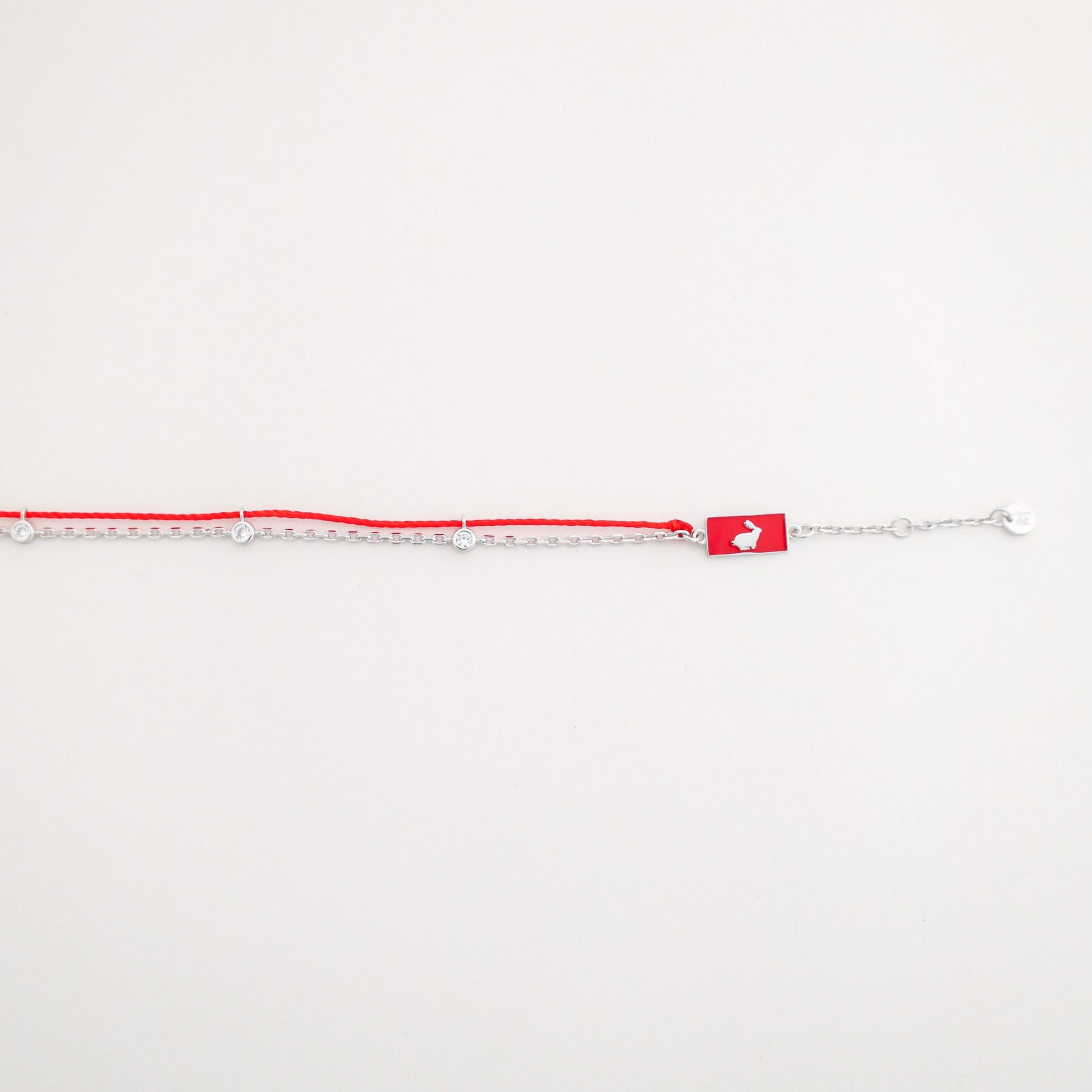 Rabbit zodiac red string bracelet with white gold chain, flat lay - Crowned