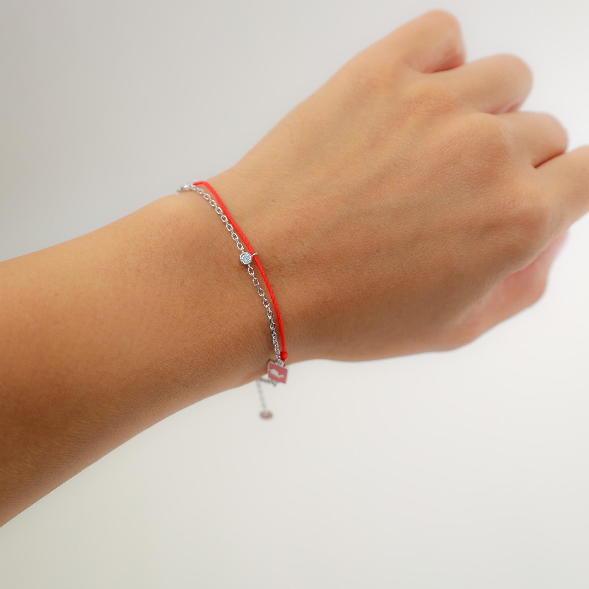 Rabbit zodiac red string bracelet with white gold chain, flat lay - Crowned
