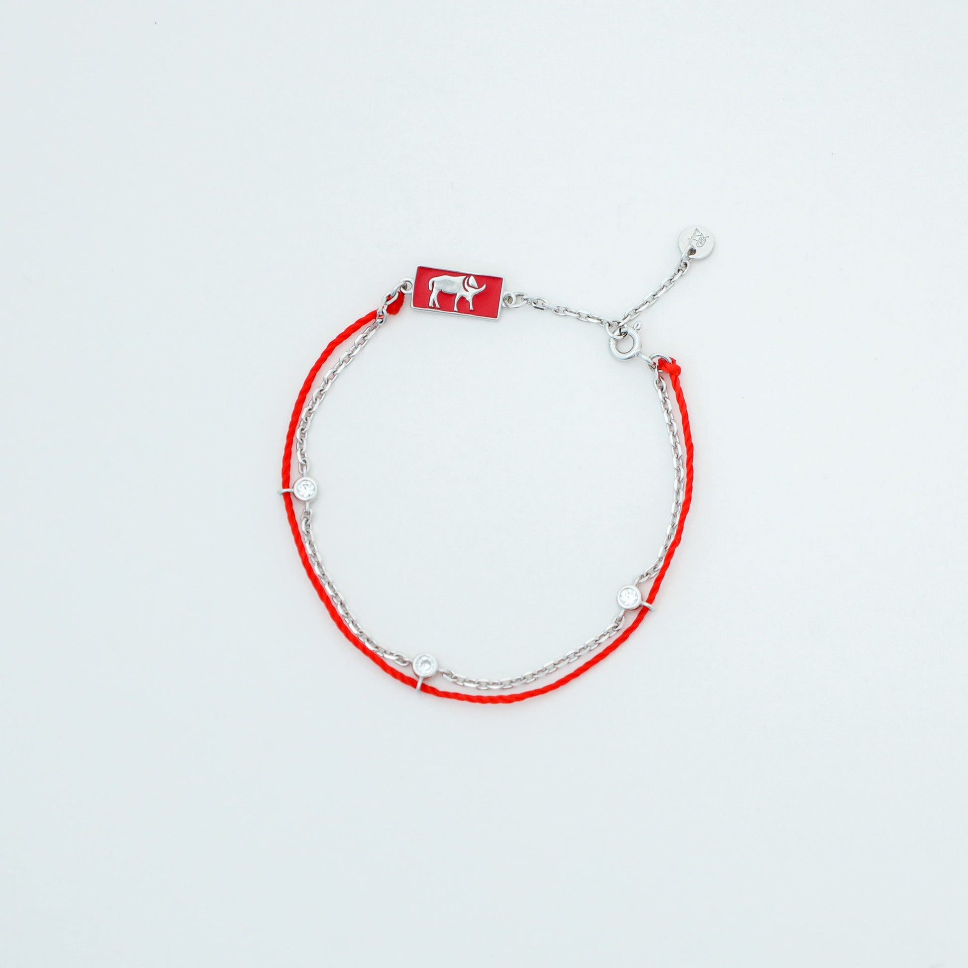 Ox zodiac red string bracelet with white gold chain, flat lay - Crowned