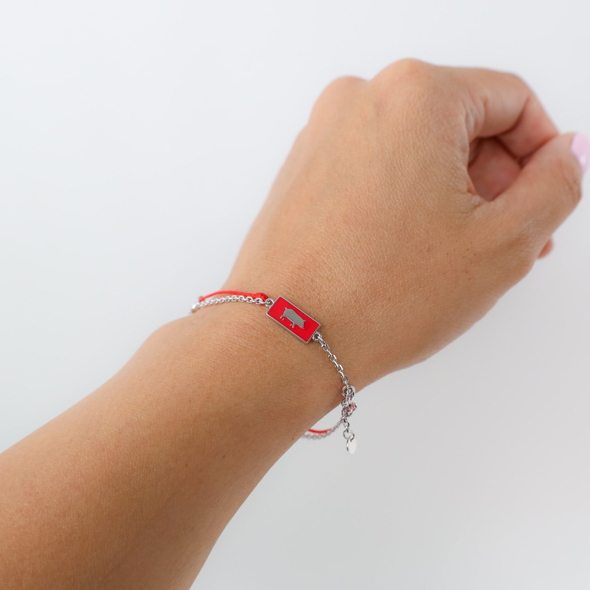 Pig zodiac red string bracelet with white gold chain, flat lay - Crowned