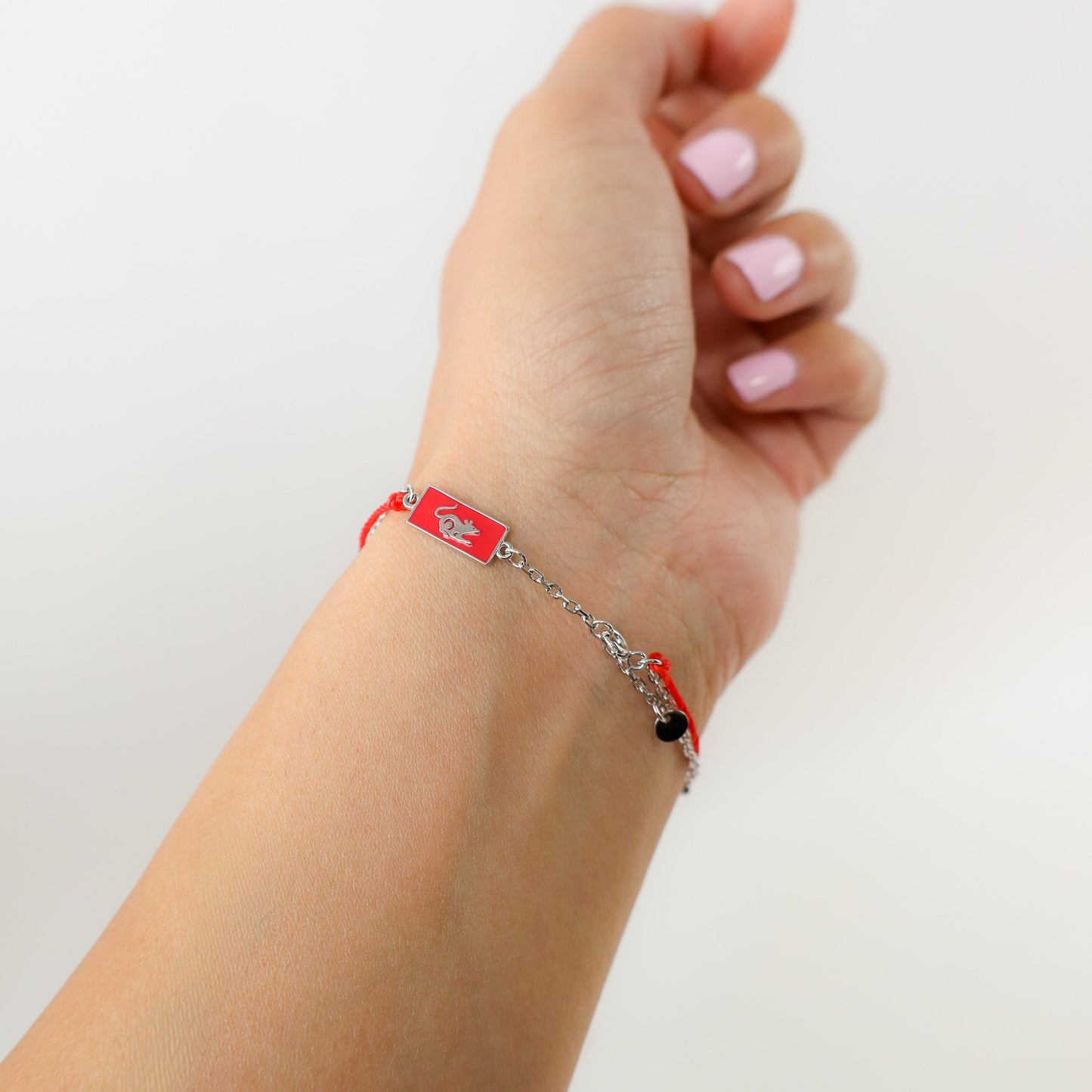 Rat zodiac red string bracelet with white gold chain, flat lay - Crowned