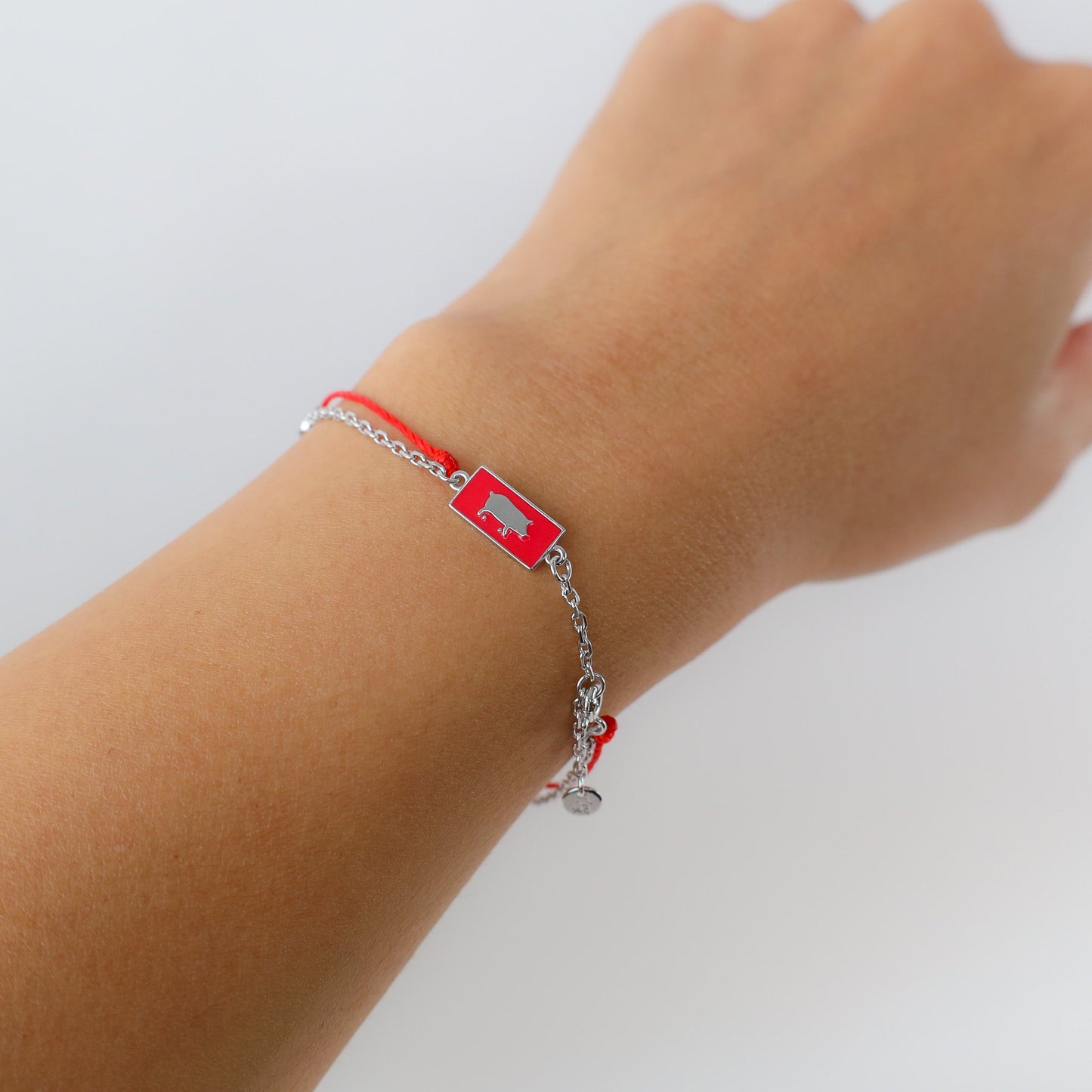 Pig zodiac red string bracelet with white gold chain, flat lay - Crowned