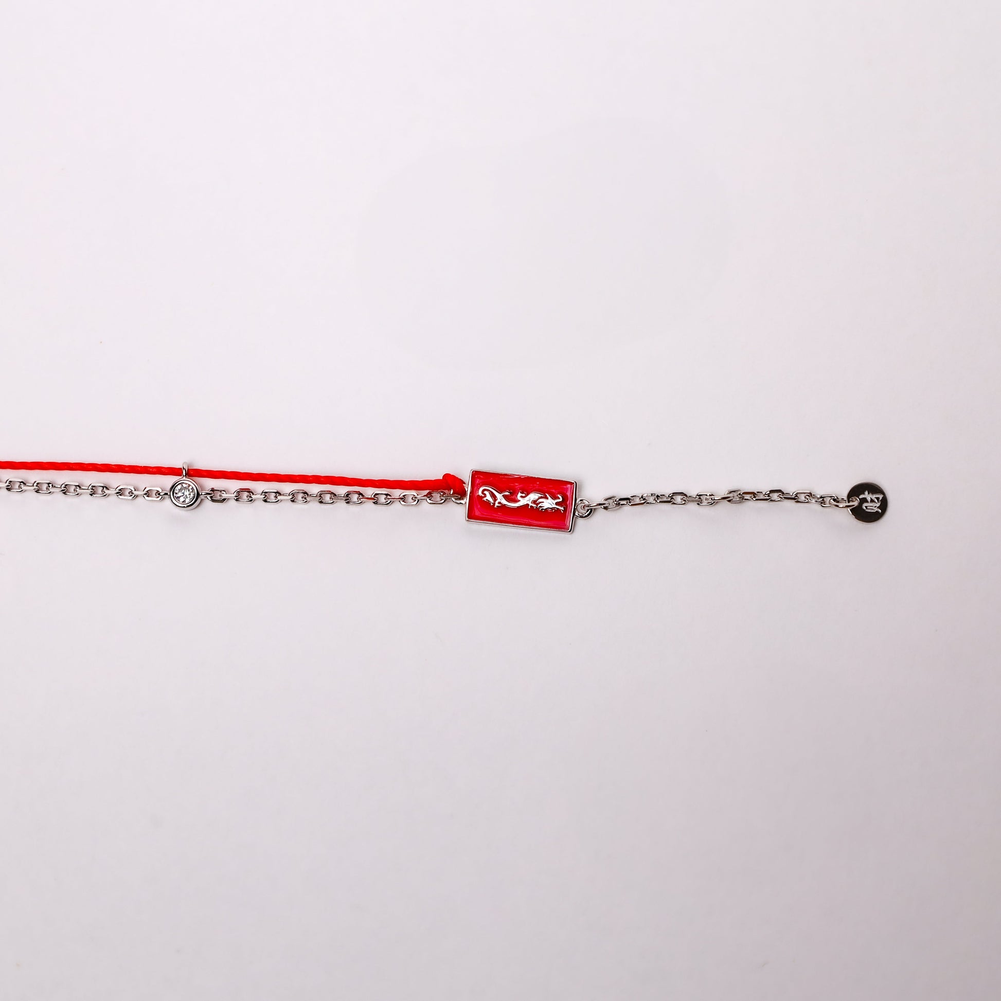 Dragon zodiac red string bracelet with white gold chain, flat lay - Crowned