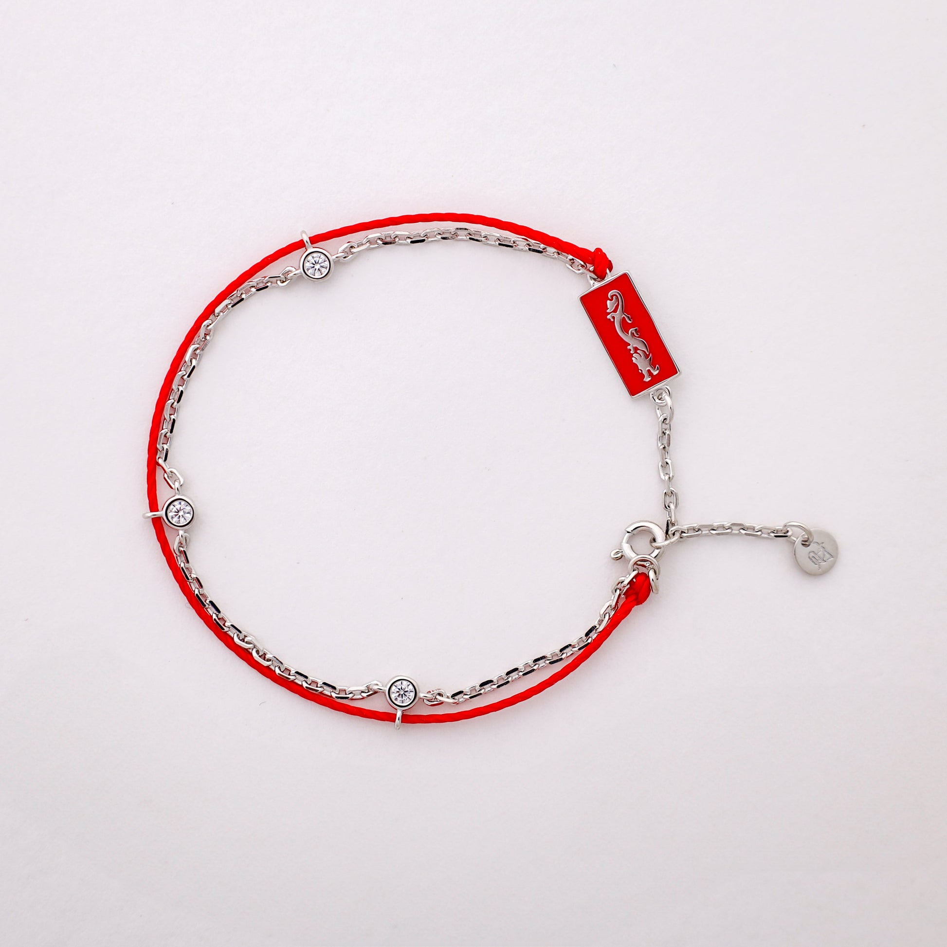Dragon zodiac red string bracelet with white gold chain, flat lay - Crowned