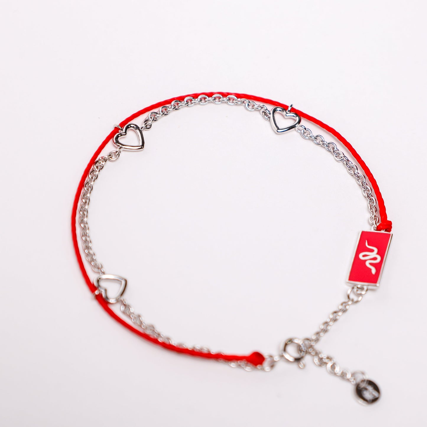 Snake zodiac red string bracelet with white gold chain, flat lay - Crowned