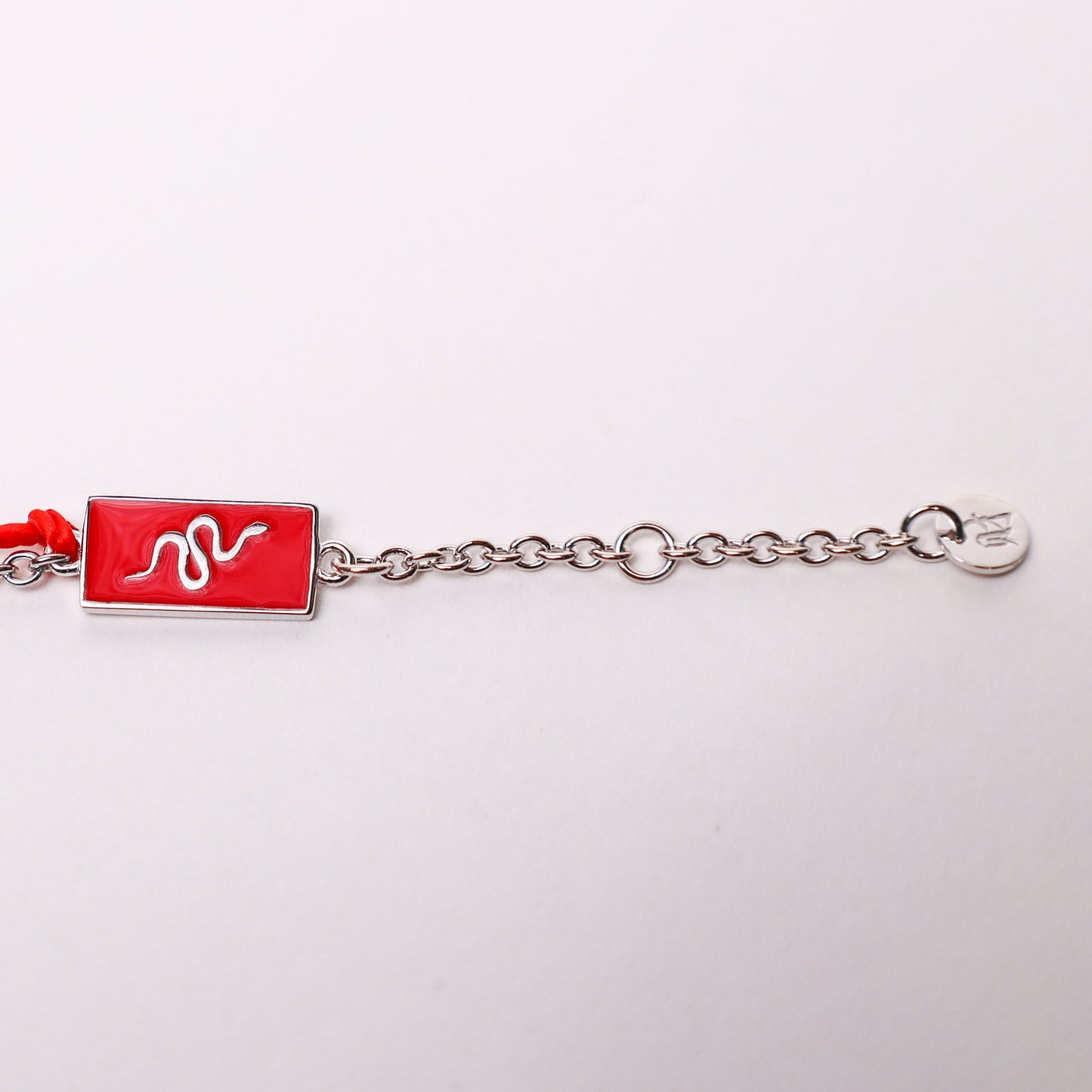 Snake zodiac red string bracelet with white gold chain, flat lay - Crowned