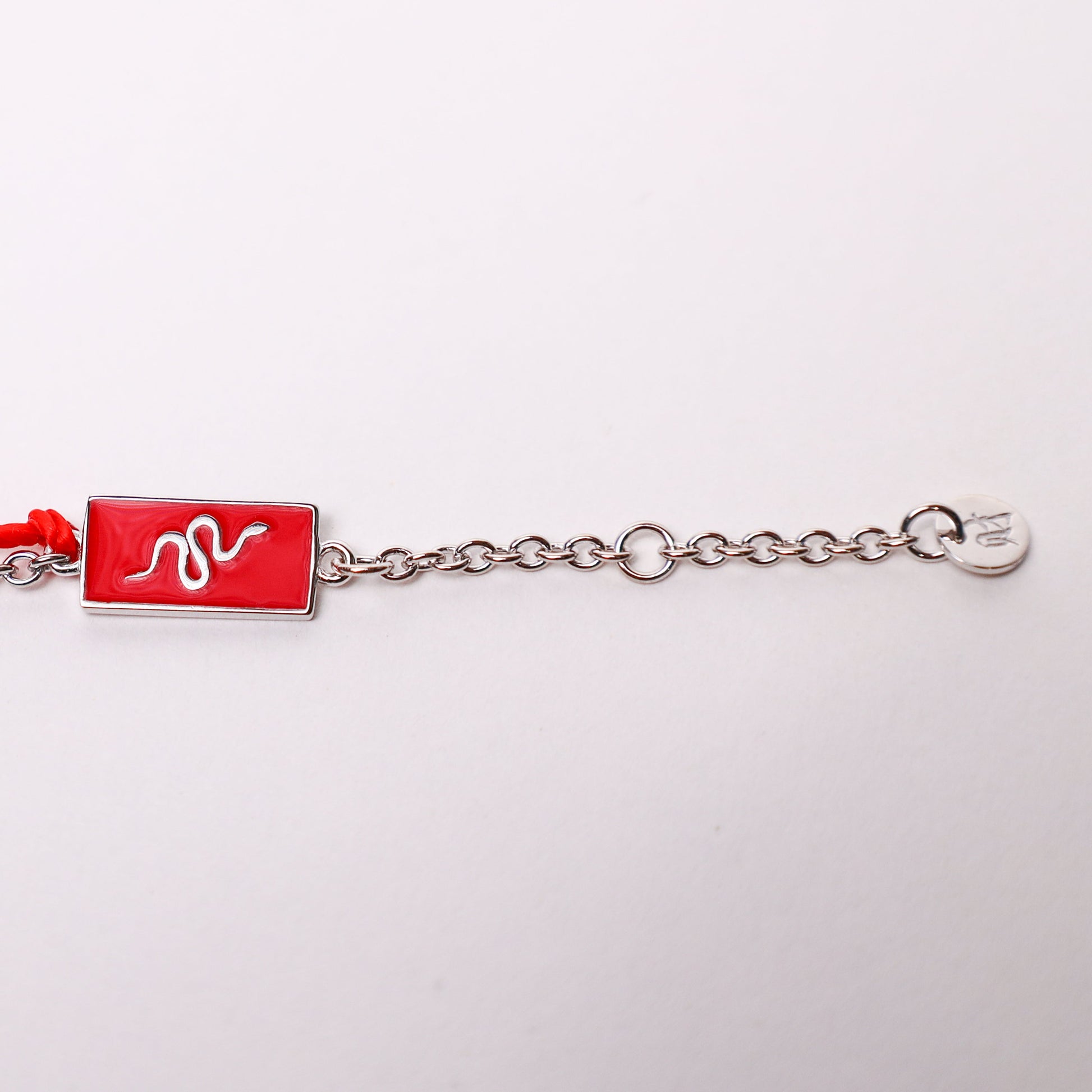 Snake zodiac red string bracelet with white gold chain, flat lay - Crowned