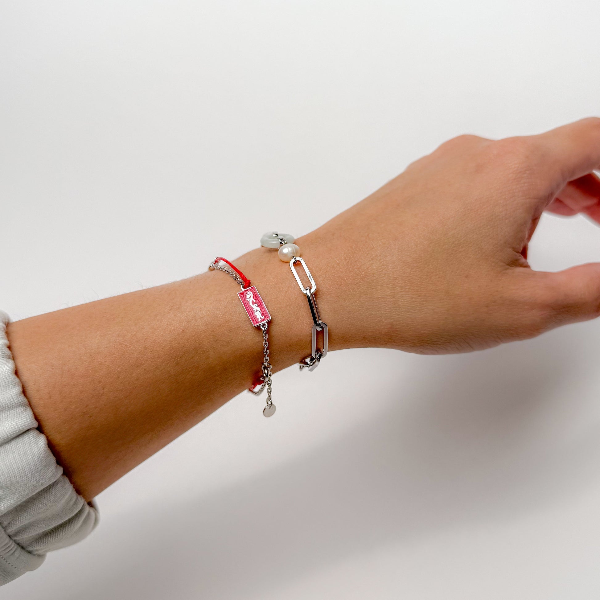 Dragon zodiac red string bracelet with white gold chain, flat lay - Crowned