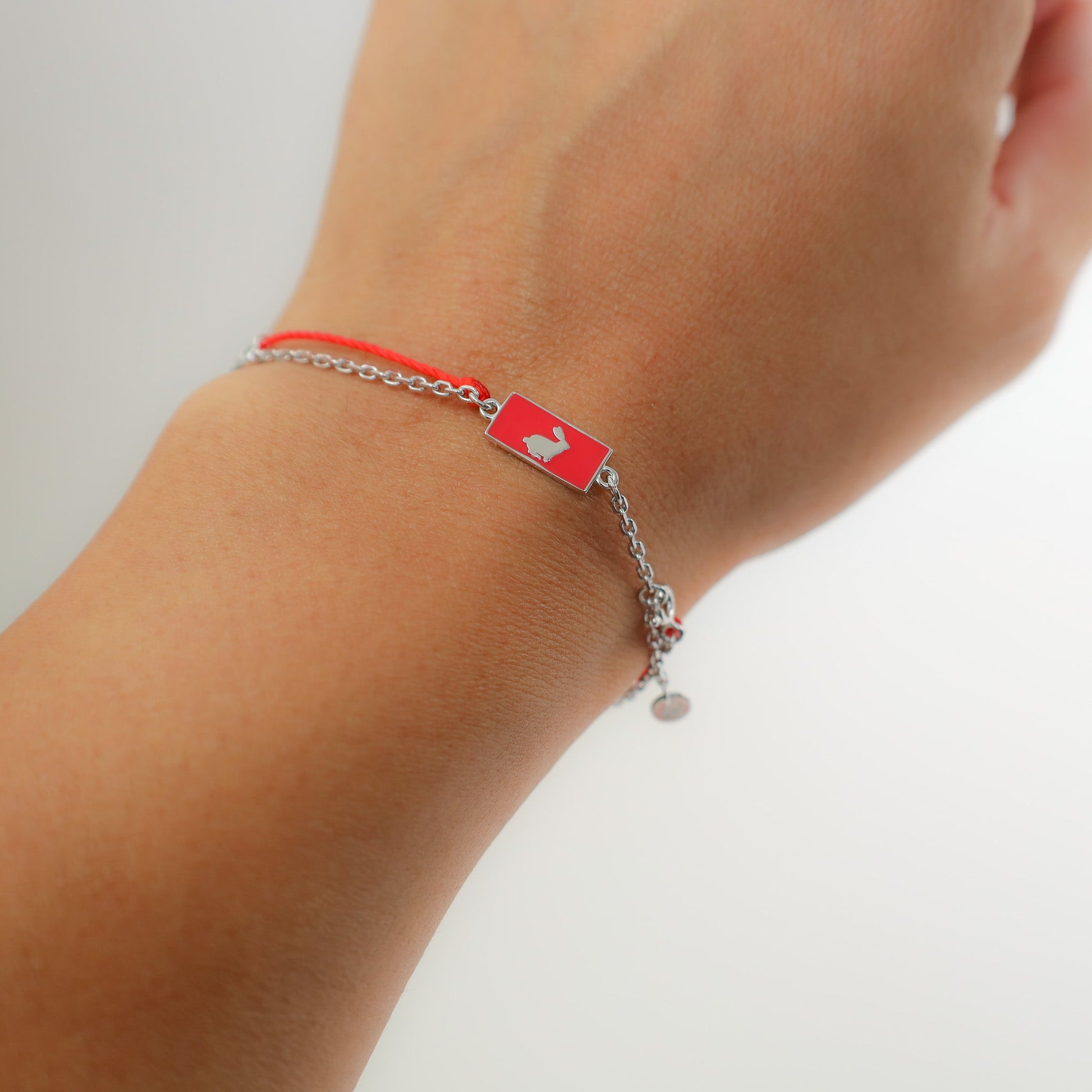 Rabbit zodiac red string bracelet with white gold chain, flat lay - Crowned